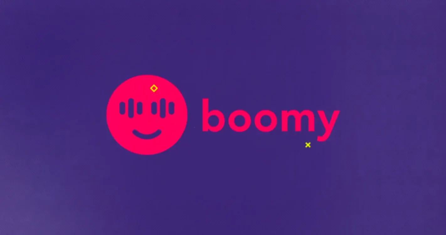 A red logo with the text "boomy" written in white in a stylized font. The background is purple.